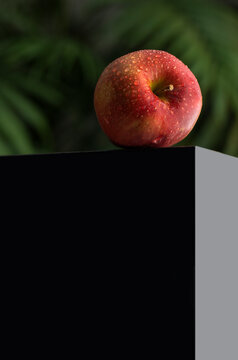 Ripe Red Apple Lying On The Edge Of A Black Table