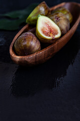 Figs with leaves in a wooden plate