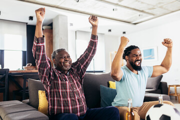 Man relax on sofa in living room with senior father scream support favorite sports team together