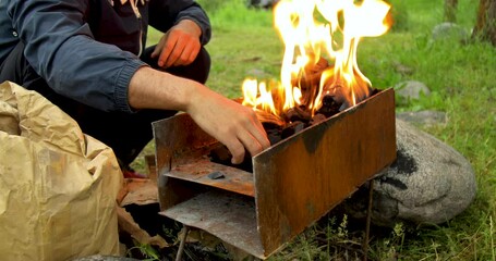Man lighting a fire in the in the brazier