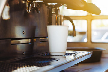 Barista making coffee in a coffee machine in a cardboard