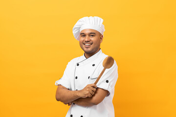 Young handsome asian man chef in uniform with hat holding ladle utensils cooking in the kitchen various gesture action on isolated yellow background. Indian man Occupation chef restaurant and hotel.
