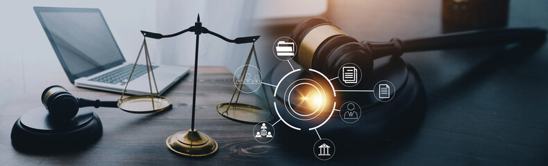 Justice and law concept.Male judge in a courtroom with the gavel, working with, computer and docking keyboard, eyeglasses, on table in morning light
