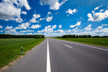 paved highway with blue sky and clouds