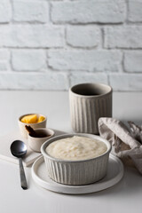 Scandinavian breakfast. Rice porridge on grey ceramic  bowl served with butter and cinnamon at yhe...