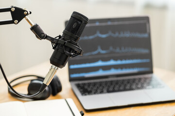 Condenser microphone in recording home studio. Content creator working with laptop host streaming radio podcast interview conversation at home broadcast studio recording waveform voice over radio