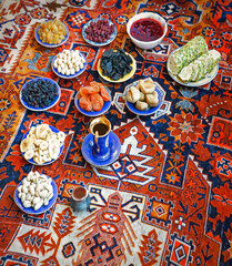 Eastern feast. Asian still life of dried fruits and nuts in plates on a carpet