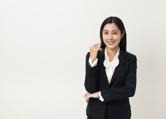 Young asian business woman smiling to camera standing pose on isolated white background. Female around 25 in suit portrait shot in studio.