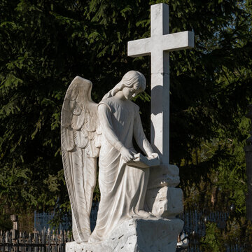 Beautiful sad angel with cross.