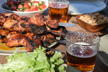 Summer picnic with barbecue, vegetables and beer