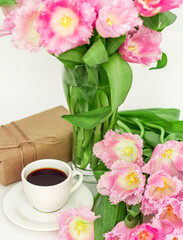 A cup of coffee with a gift and tulips, A gift for a woman on Mother's Day close-up