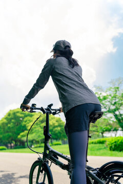 ミニベロでサイクリングする女性　小径自転車　折り畳み自転車