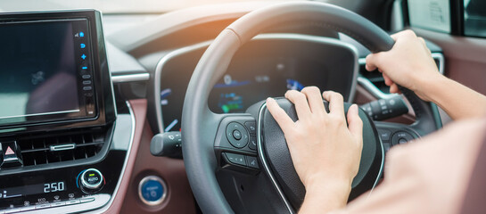 woman driver honking a car during driving on traffic road, hand controlling steering wheel in...