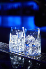 Two empty glasses with ice cubes on the bar