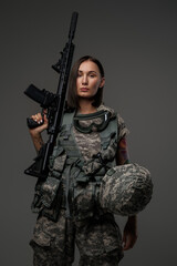 Shot of militant woman dressed in camouflage protective uniform looking at camera.