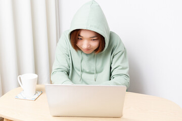 パソコンを使ってハッキングしている女性