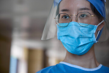Fototapeta na wymiar Close up view of a doctor inside hospital wearing surgical mask and a face shield.