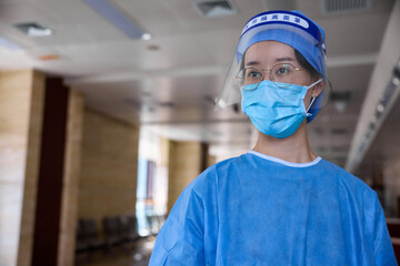 Close up view of a doctor inside hospital wearing surgical mask and a face shield.