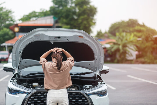 woman driver standing near a problem car. Breakdown or broken car on road. Vehicle Insurance, maintenance and service concept