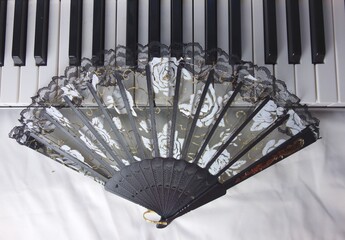 black woman fan on piano keyboard