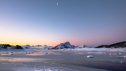 Simultaneous sunrise and sunset during the arctic winter in Lofoten, Norway. View of Offersøykammen in the distance. © Emmeli