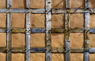 Die quadratischen, mit Lehm verputzten Gefache der Fassade eines Fachwerkhauses