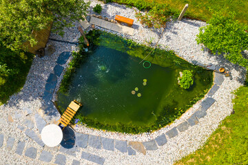 Garden pond. Relaxation zone with fish farming in an organic orchard from above. Sustainable...