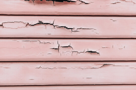 Textured wainscoting wall paneling with chipped and cracked paint chips falling off.