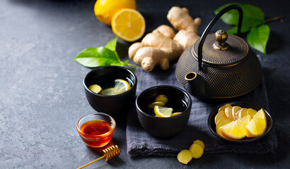 Obraz na płótnie Canvas Ginger tea with lemon. Grey background. Healthy immunity boost hot drink. Close up. Copy space.