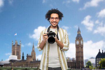 travel, tourism and people and concept - happy smiling man, photographer or tourist in glasses with...