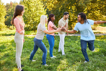 Young people giving high five in the park in summer