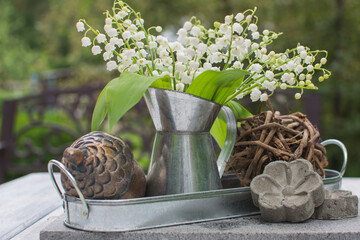 Bouquet of lilies of the valley in an antique metal jug.