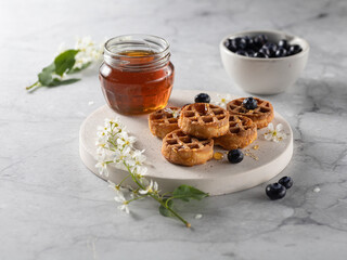 homemade belgian waffels with blueberry and honey on marble table. Vertical