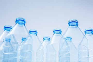 Plastic bottles on a blue background as a symbol of ecological catastrophes or production of plastic
