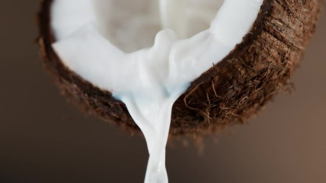 Cracked coconut with splashing milk, super slow motion.