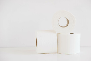 Rolls of white toilet paper on a white background