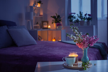 cozy bedroom in  evening with flowers and tea