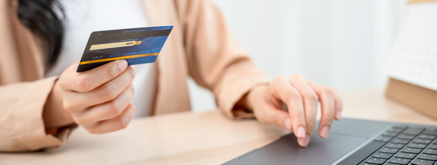 woman uses a credit card to pay for goods after shopping online through a socially marketed merchant's website. The buyer pays for water, electricity and telephone bills via computer by debit card.