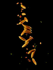 Austrian Schupfnudeln fly through the air, panned in a pan in front of a black background