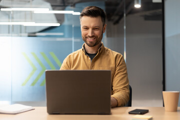 Confident Businessman Working Online On Laptop Computer In Modern Office
