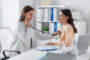 medicine, healthcare and people concept - female doctor with stethoscope and woman patient at hospital