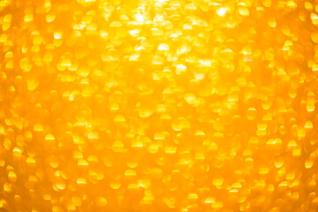 Background texture of shiny golden bokeh. Beautiful festive christmas background for greeting design. Nacreous sparkling yellow texture.