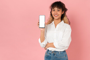 Naklejka premium Studio shot of Beautiful Asian woman holding smartphone mockup of blank screen and smiling on pink background.