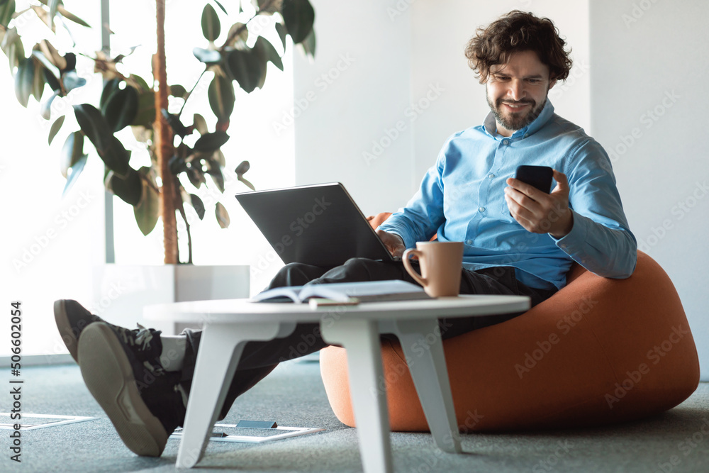 Sticker Portrait of smiling man using smartphone and pc at office