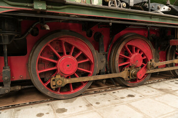 Fototapeta na wymiar old metal locomotive wheels in red