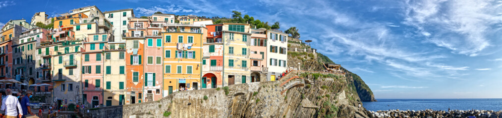 Fototapeta na wymiar Riomaggiore, Liguria, Italy - June 25, 2021: summer view of the famous touristic village of the Cinque Terre and its sharp cliffs