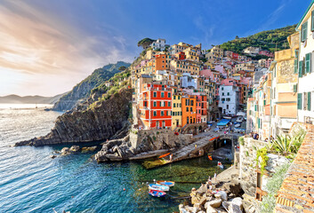 Fototapeta na wymiar Riomaggiore, Liguria, Italy - June 25, 2021: sunset summer view of the famous touristic village of the Cinque Terre and its sharp cliffs