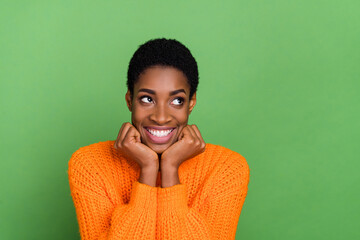 Photo of sweet millennial brunette lady hands face look promo wear orange sweater isolated on green...