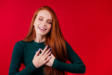 Naklejka premium happy redhair ginger woman in studio background feeling heart thanks