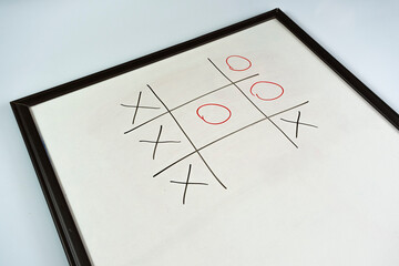 XOX game with black red color marker on a whiteboard, competition and strategy idea, playing xox game concept, sitting view